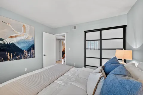 a bedroom with a bed and wooden floor