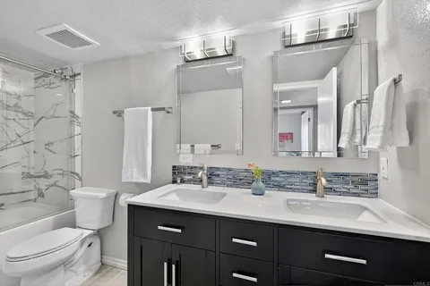 a bathroom with a sink vanity mirror and toilet