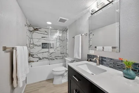 a bathroom with a sink a toilet and shower