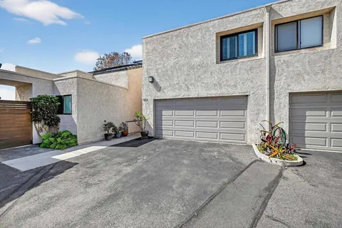 a view of a house with garage and plants
