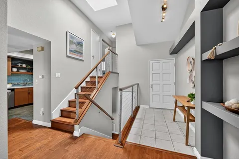 a living room with stairs and a wooden floor
