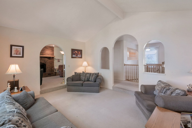 11072 Windy Peak Ridge Drive, Unit 32 Sandy, UT 84094 - Photo 13 of 30 Vaulted ceiling with exposed beam, multiple arched architectural doorways, built-in wall niche, and carpeted flooring throughout