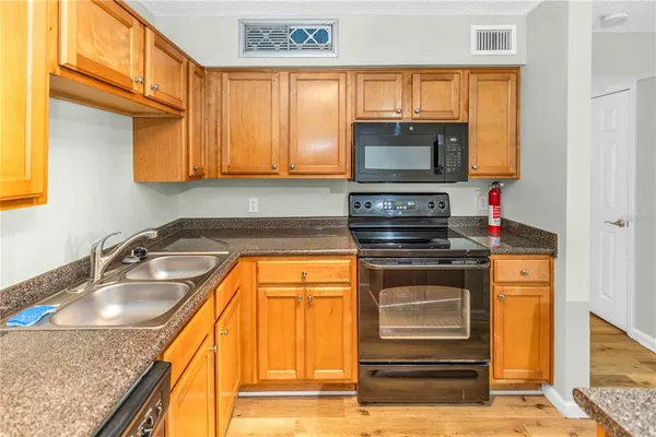 a kitchen with stainless steel appliances granite countertop a sink stove and cabinets