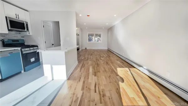 a open dining room with stainless steel appliances kitchen island granite countertop a table chairs and a microwave