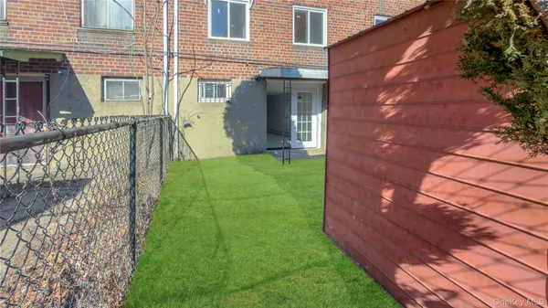 a view of a house with brick walls and a small yard