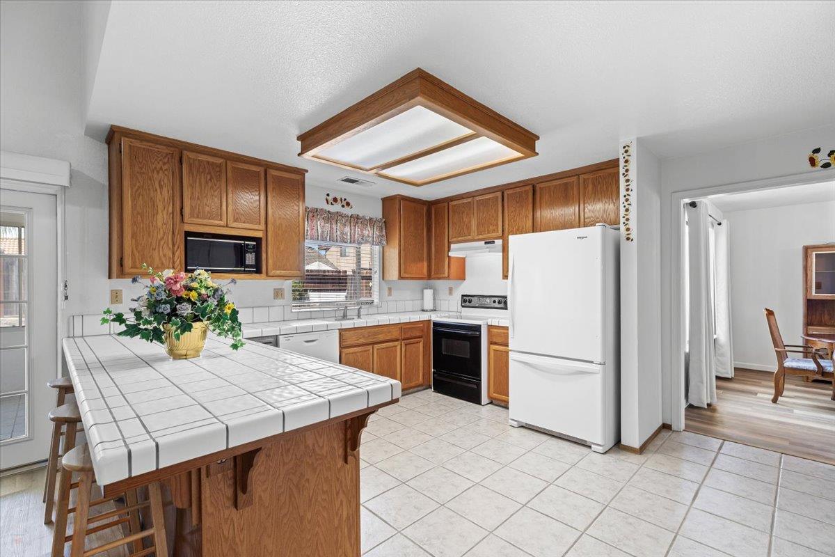 3005 Willetts Way Ceres, CA 95307 - Photo 7 of 29 a kitchen with a refrigerator a stove a microwave and cabinets