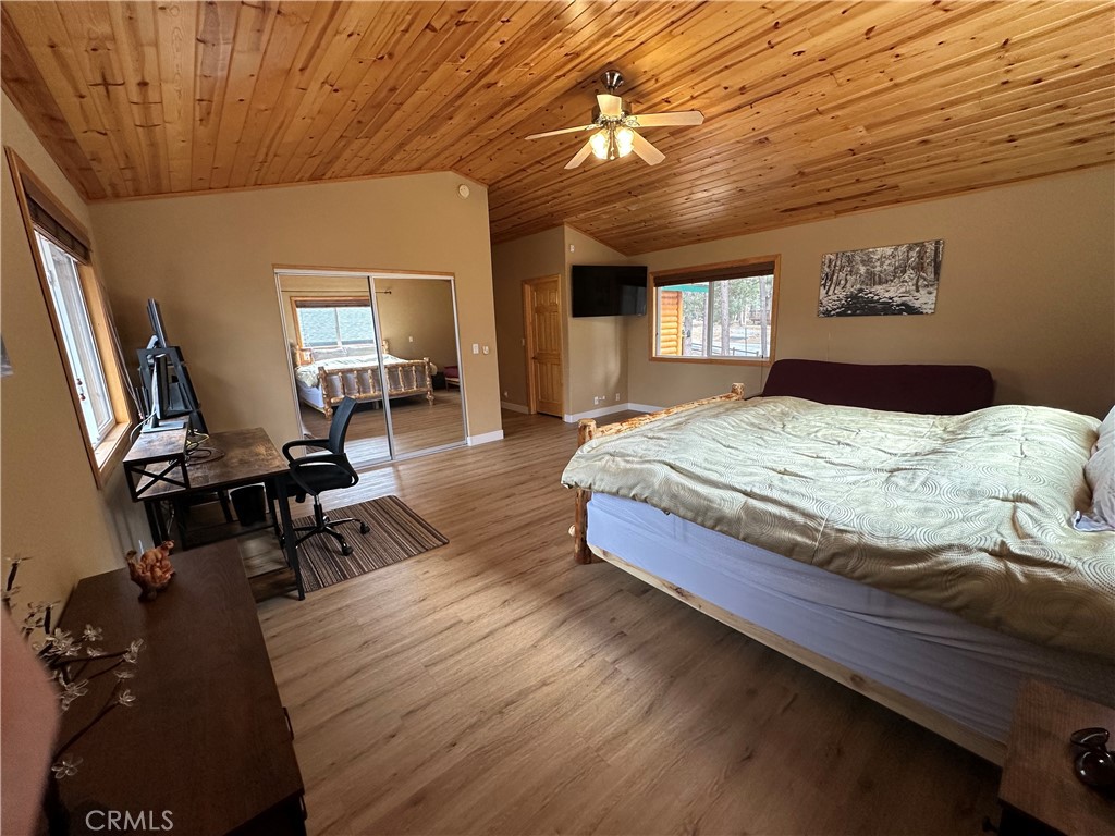 43632 Shasta Road Big Bear Lake, CA 92315 - Photo 12 of 30 a bedroom with a bed wooden floor and a desk