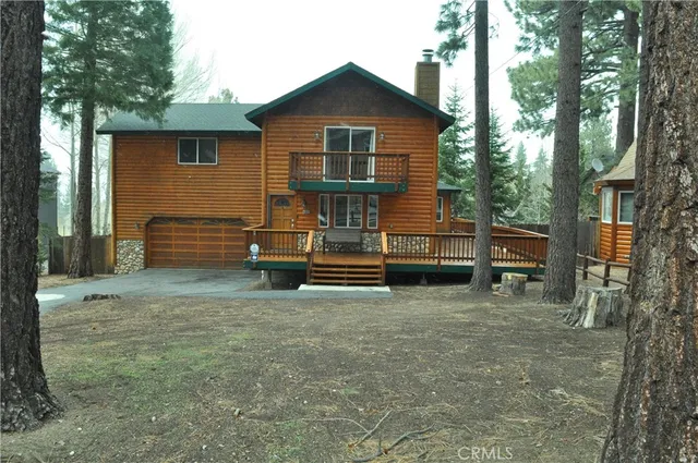 a view of backyard with wooden fence and a large tree
