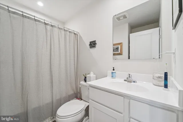 a bathroom with a sink a toilet and shower curtain