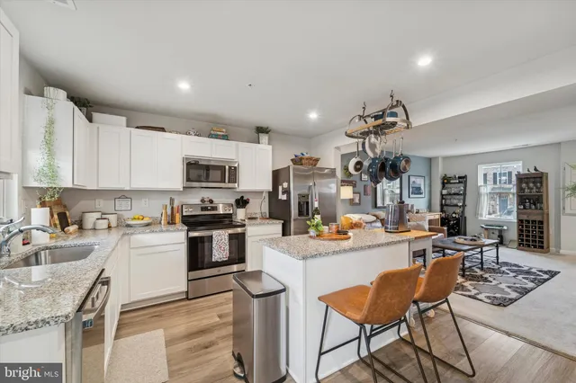 a kitchen with a sink a stove and chairs