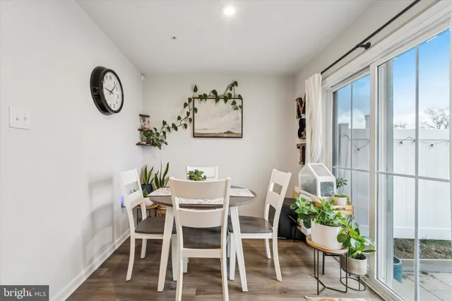 a dining room with furniture potted plants and wooden floor