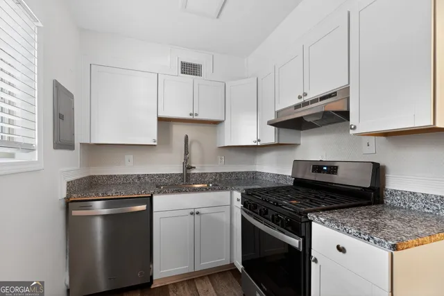 a kitchen with stainless steel appliances granite countertop a sink stove and cabinets