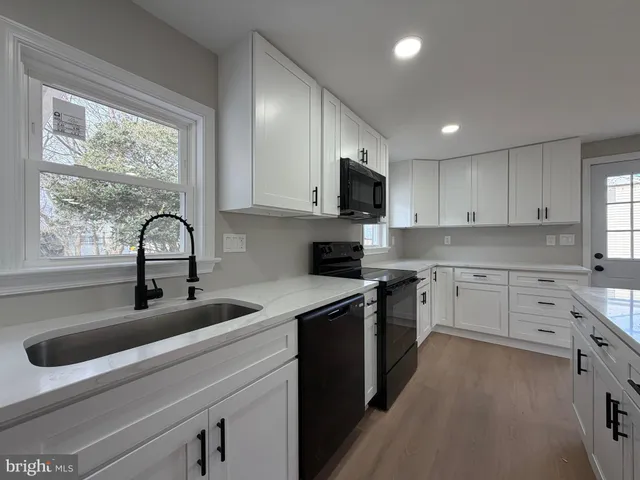 a kitchen with white cabinets a sink and appliances