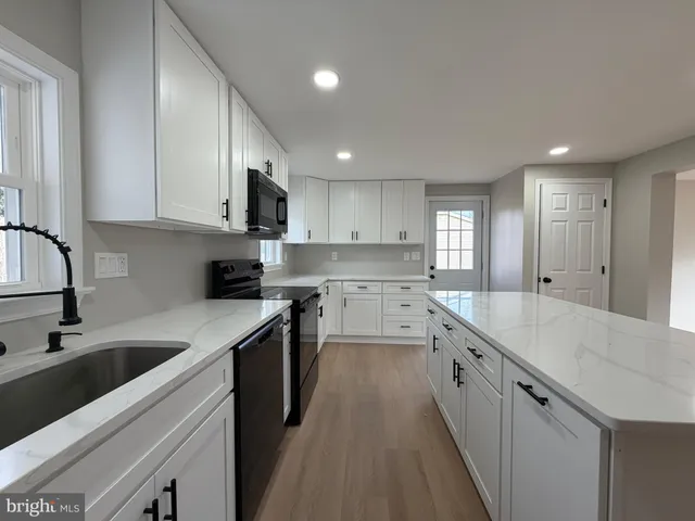 a kitchen with granite countertop a sink and cabinets