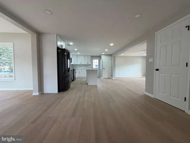 a view of a kitchen with a refrigerator wooden floor and a kitchen