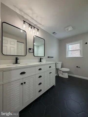 a bathroom with a toilet sink and mirror