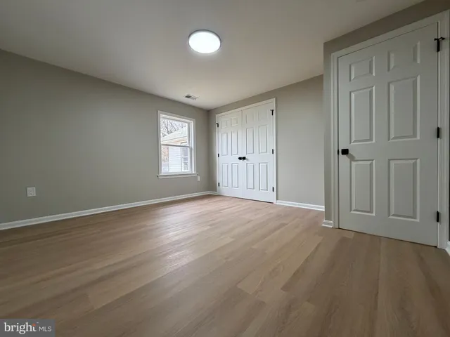 an empty room with wooden floor and window