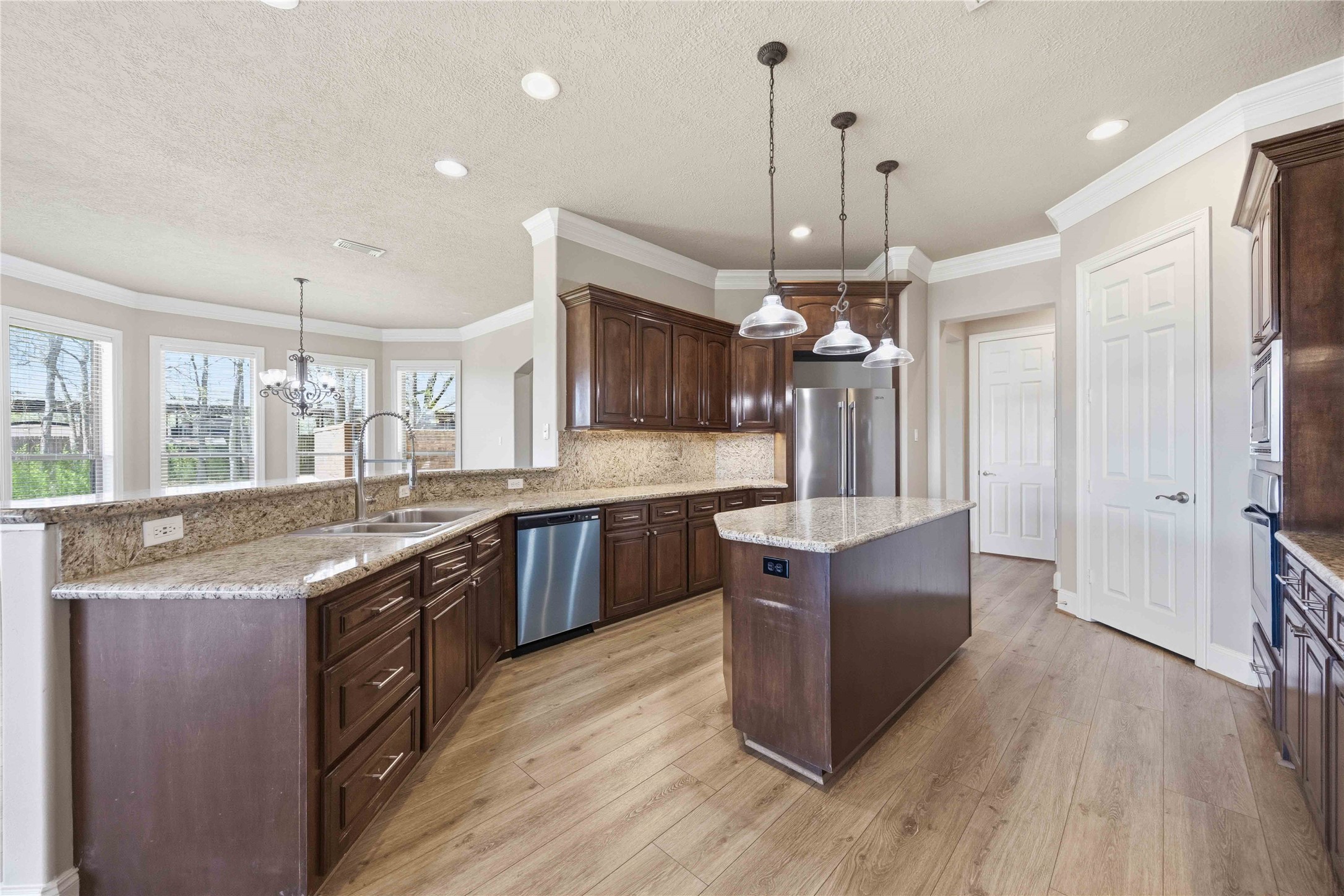 1930 Old River Road Montgomery, TX 77356 - Photo 12 of 49 A well-designed kitchen offers granite countertops, under-cabinet lighting, a central island, and a pantry. It opens to the living room to the side and the dining room on the other side of the breakfast bar.