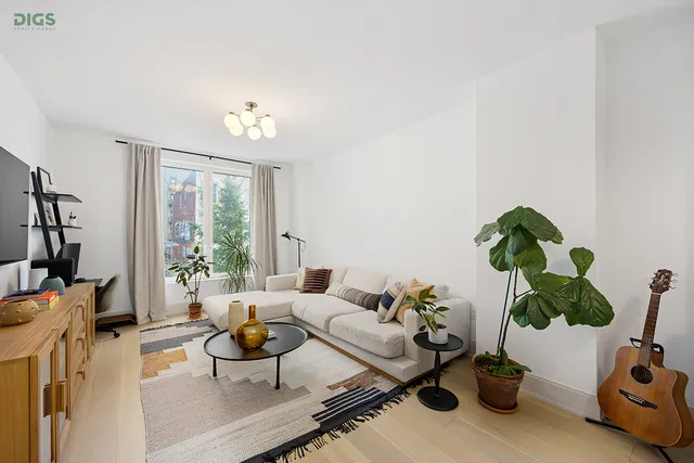 a living room with furniture a potted plant and a window
