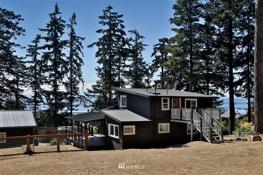 a front view of a house with a tree