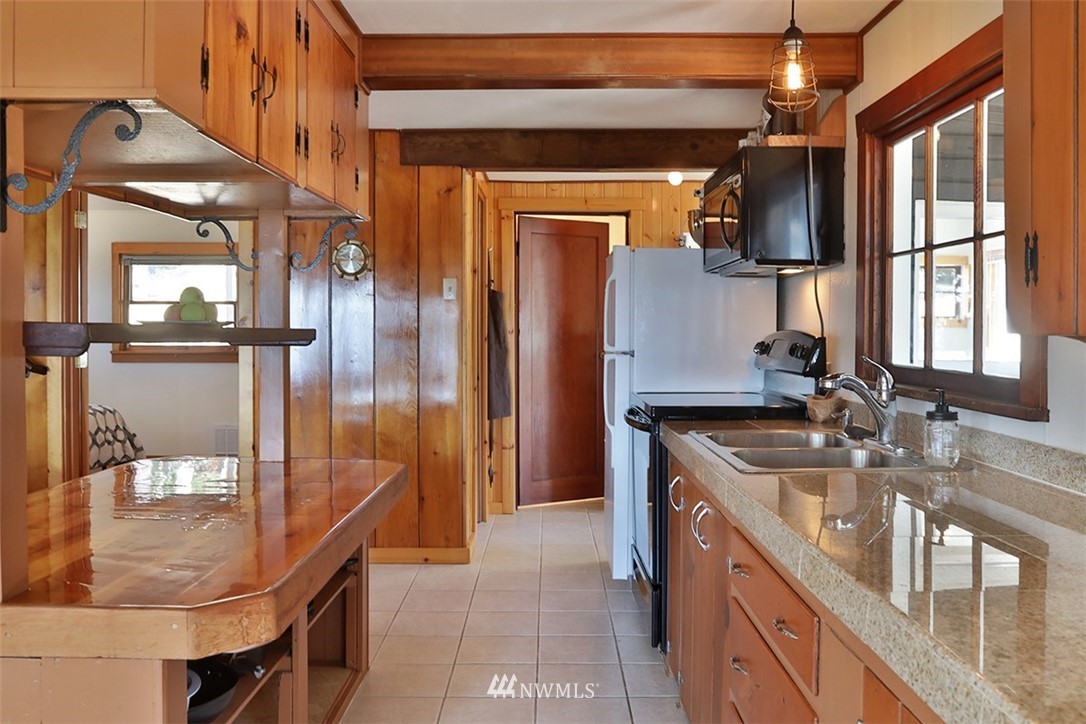 5837 Mutiny Bay Road Freeland, WA 98249 - Photo 11 of 40 a bathroom with a granite countertop sink a mirror and shower