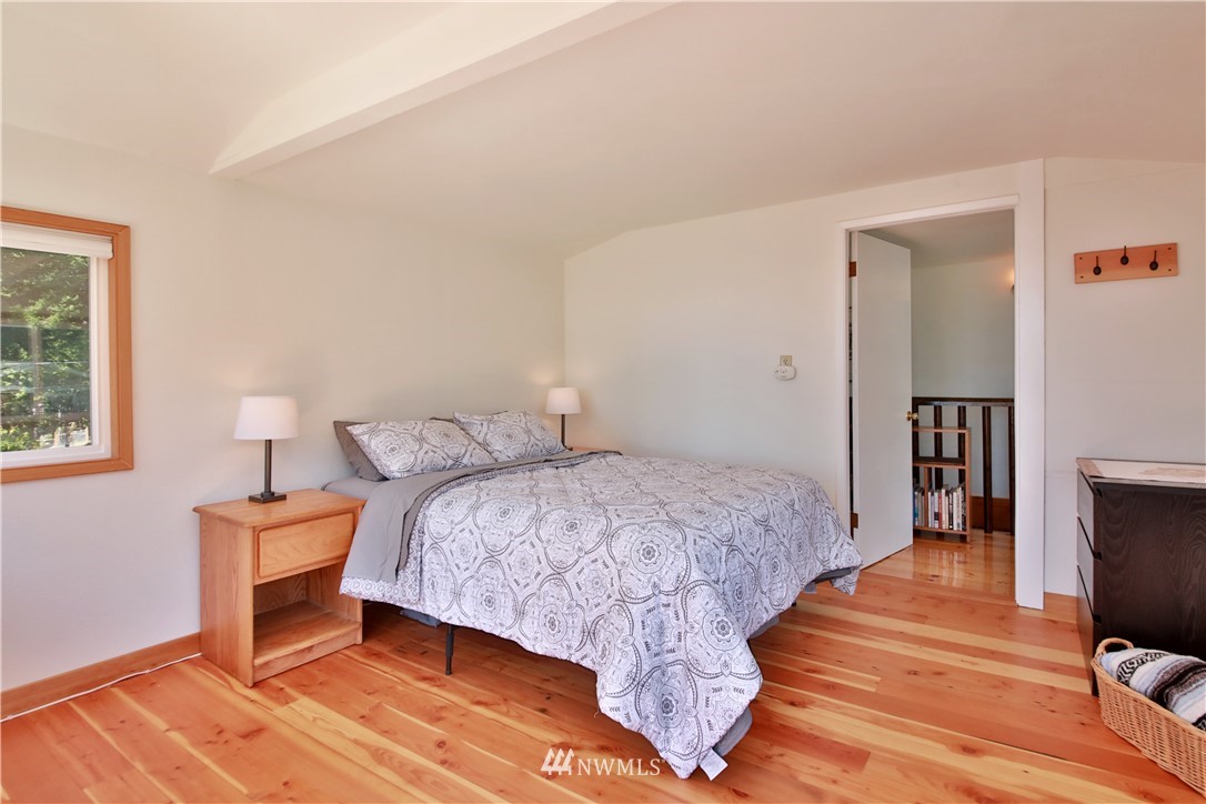 5837 Mutiny Bay Road Freeland, WA 98249 - Photo 20 of 40 a bedroom with a bed and wooden floor