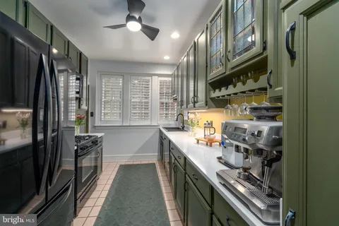 a kitchen with stainless steel appliances a sink a stove a refrigerator and cabinets