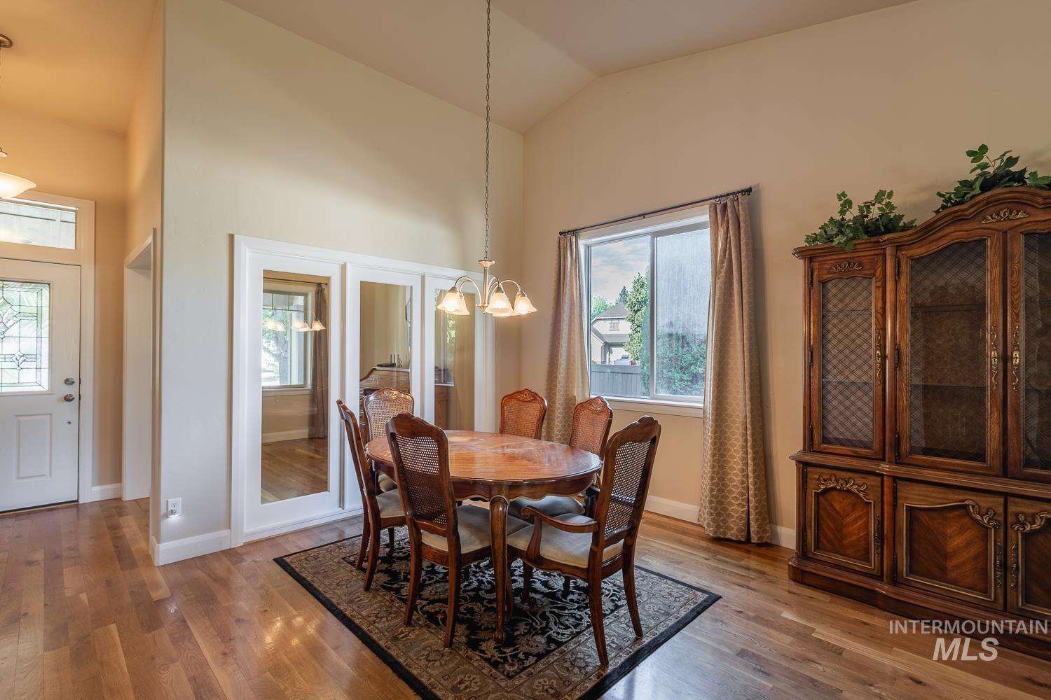 1186 East Observation Street Meridian, ID 83642 - Photo 16 of 33 Dining area featuring vaulted ceilings, wood-finish flooring, and a decorative chandelier