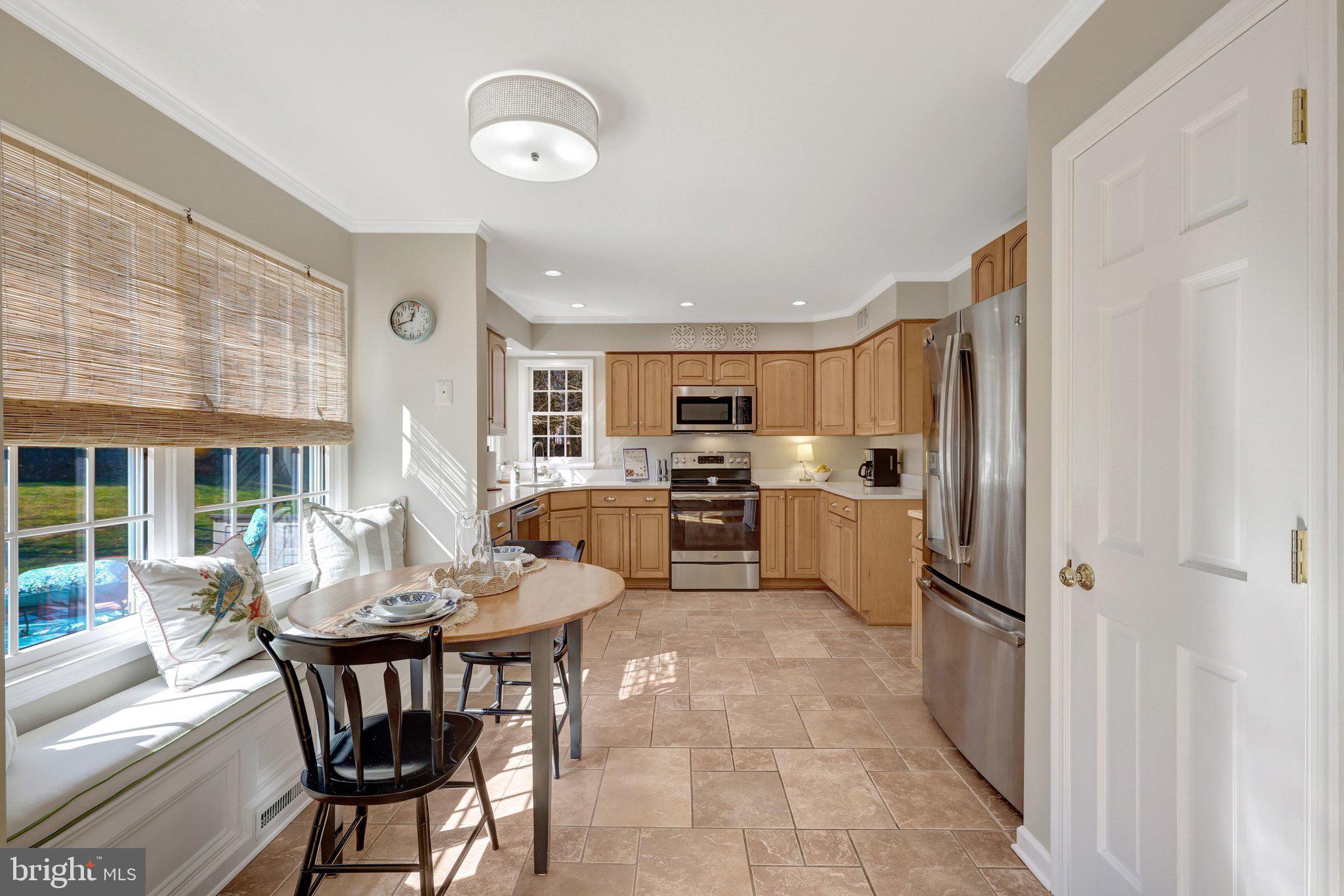 21039 Barcroft Way Sterling, VA 20164 - Photo 14 of 63 a kitchen with a table chairs refrigerator and cabinets