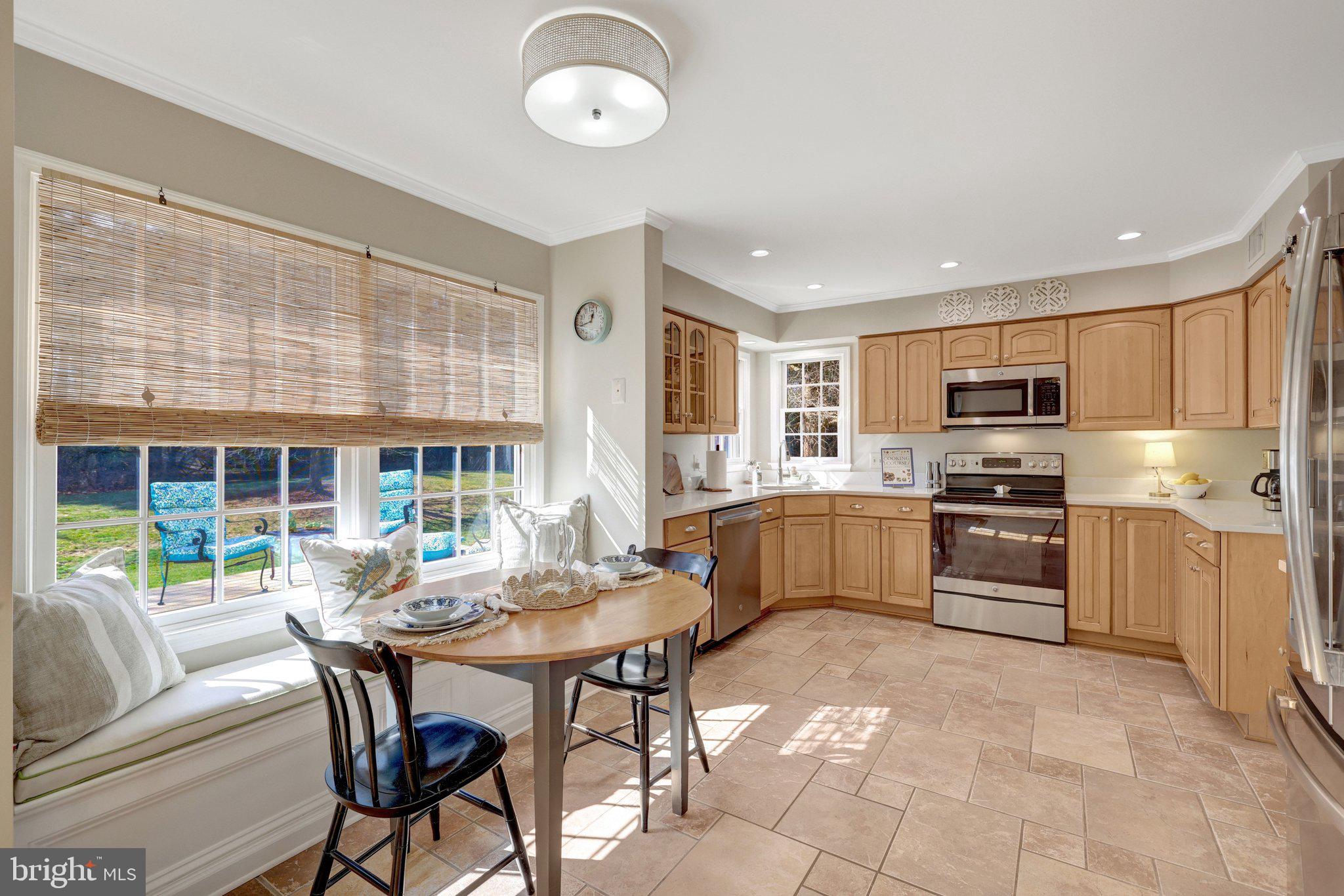 21039 Barcroft Way Sterling, VA 20164 - Photo 15 of 63 a kitchen with granite countertop a stove top oven a sink dishwasher a dining table and chairs with wooden floor