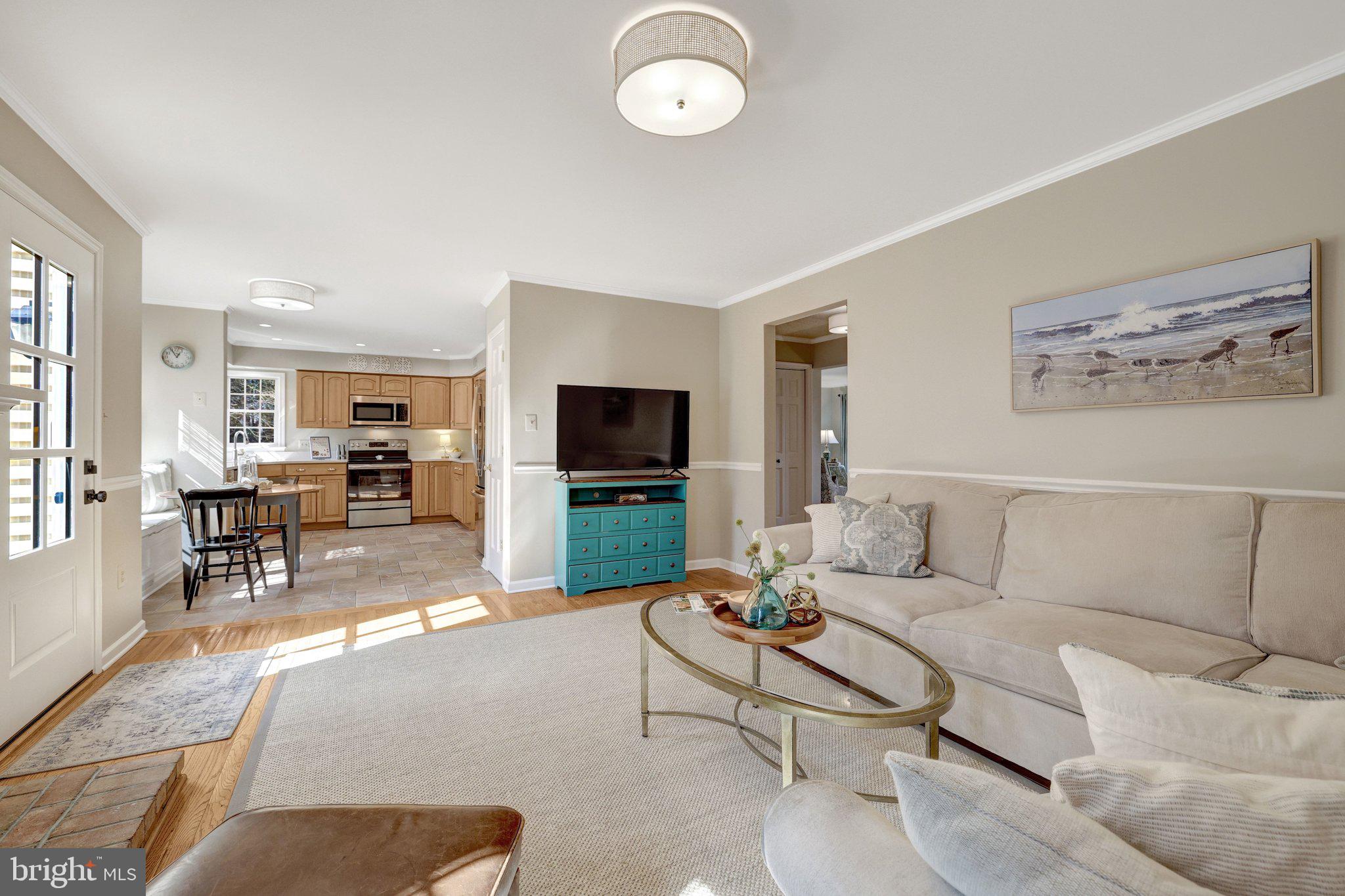 21039 Barcroft Way Sterling, VA 20164 - Photo 27 of 63 a living room with furniture a dining table and a flat screen tv