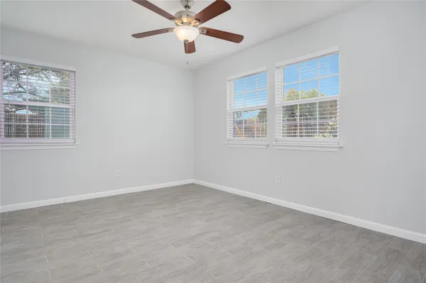 an empty room with a window and a fan