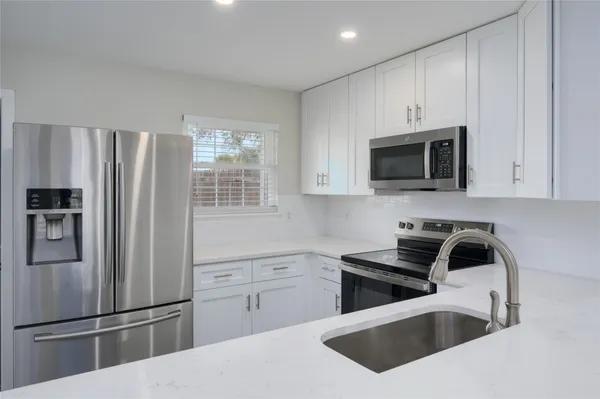a kitchen with a refrigerator stove and microwave
