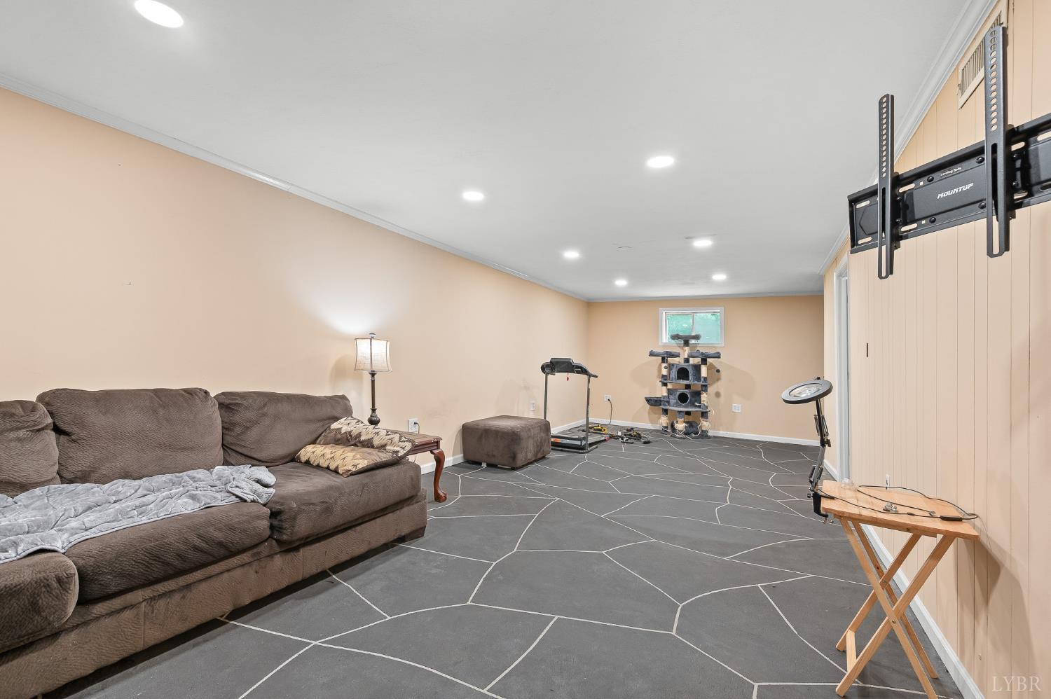 969 Hawkins Road Evington, VA 24550 - Photo 27 of 40 The large "rec room" on terrace level. The window wall and the wall behind the couch (front wall of house) had carbon fiber strips installed, sump pump installed, french drain installed