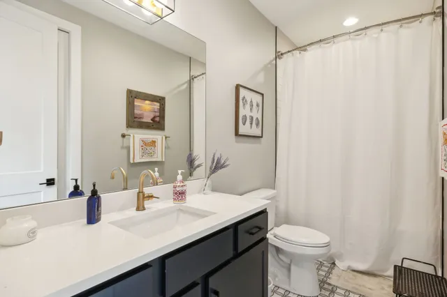 a bathroom with a sink vanity mirror and toilet