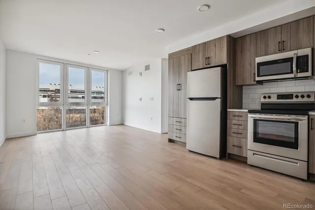 a kitchen with granite countertop a refrigerator and a stove top oven