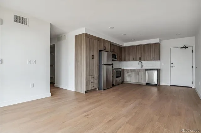 a view of a kitchen with stainless steel appliances a refrigerator and a stove top oven