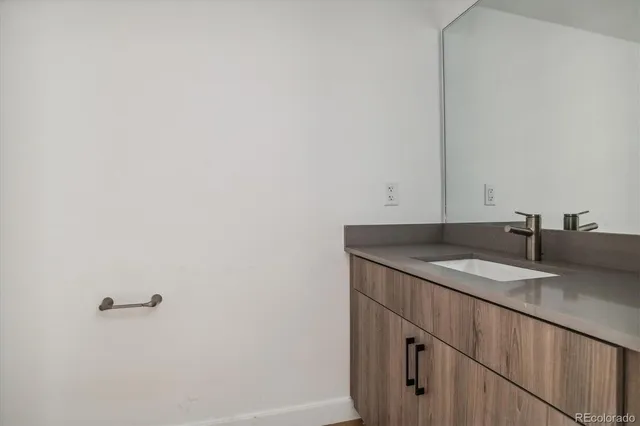 a bathroom with a granite countertop sink and a mirror