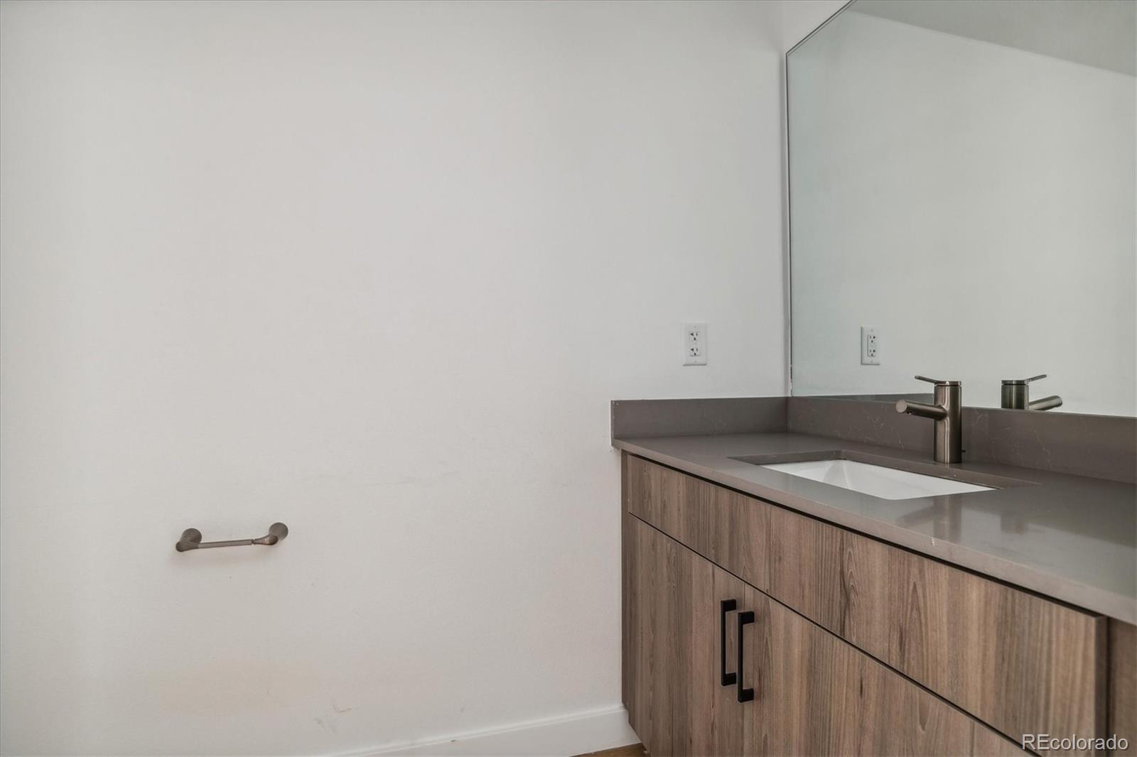3575 Chestnut Place, Unit 402 Denver, CO 80216 - Photo 10 of 16 a bathroom with a granite countertop sink and a mirror