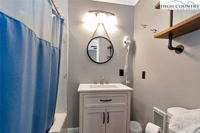 a bathroom with a sink mirror and toilet