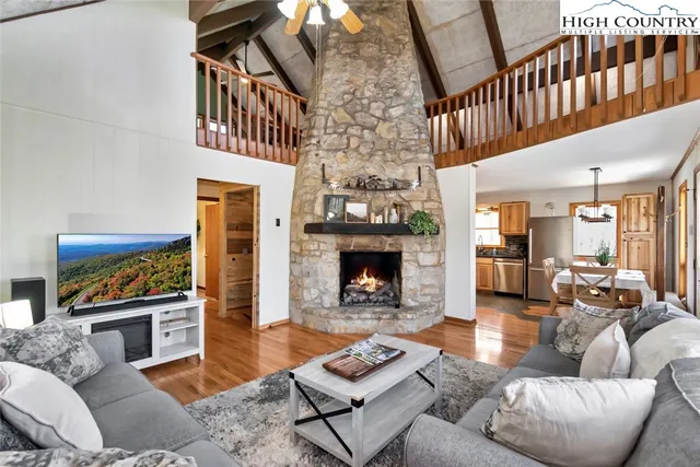 a living room with furniture a fireplace and a large window