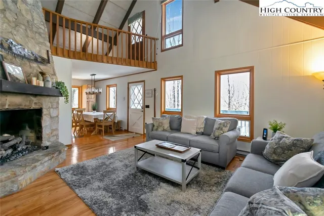 a living room with furniture a fireplace and a large window