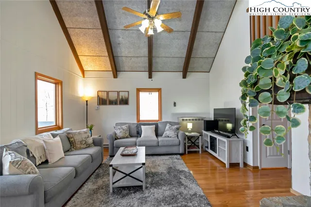 a living room with furniture a chandelier and a flat screen tv