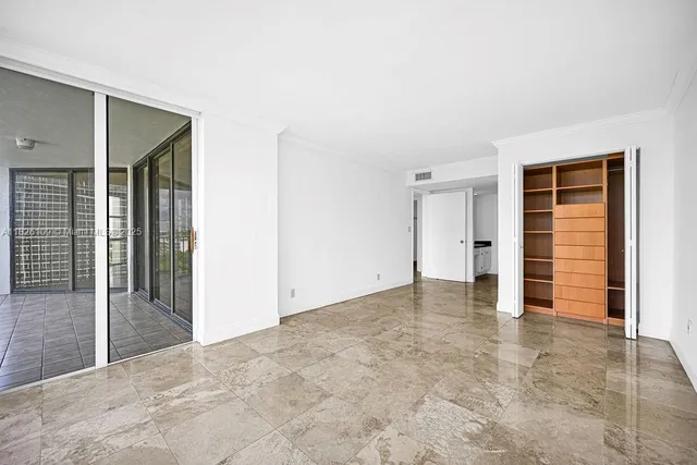 an empty room with closet and a bathroom