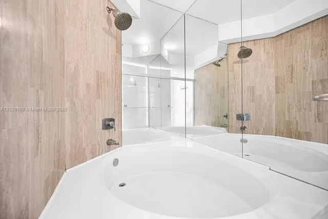 a white bath tub sitting under a shower
