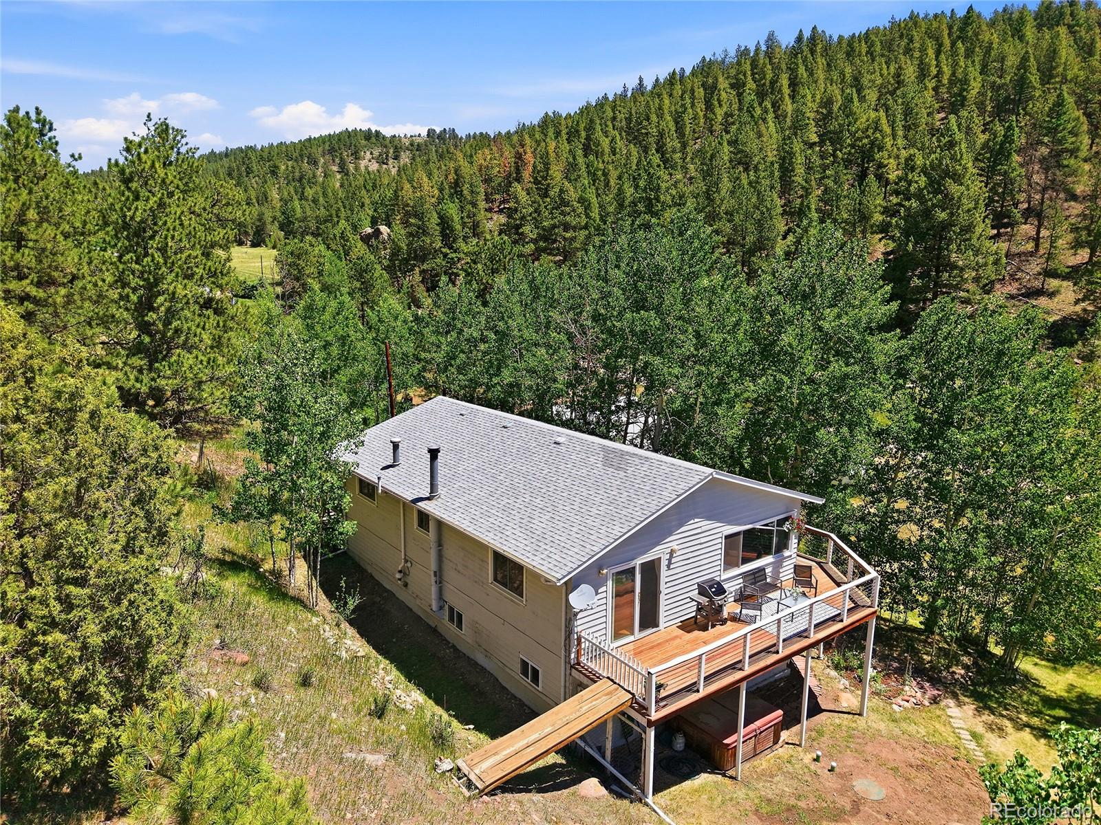 427 Brookside Drive Bailey, CO 80421 - Photo 35 of 37 a roof deck with table and chairs under an umbrella