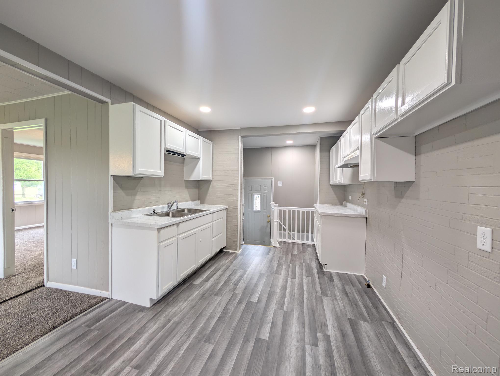 7032 Neff Road Mount Morris, MI 48458 - Photo 8 of 20 Kitchen featuring white cabinetry, light countertops, wooden walls, light wood-style flooring, and recessed lighting