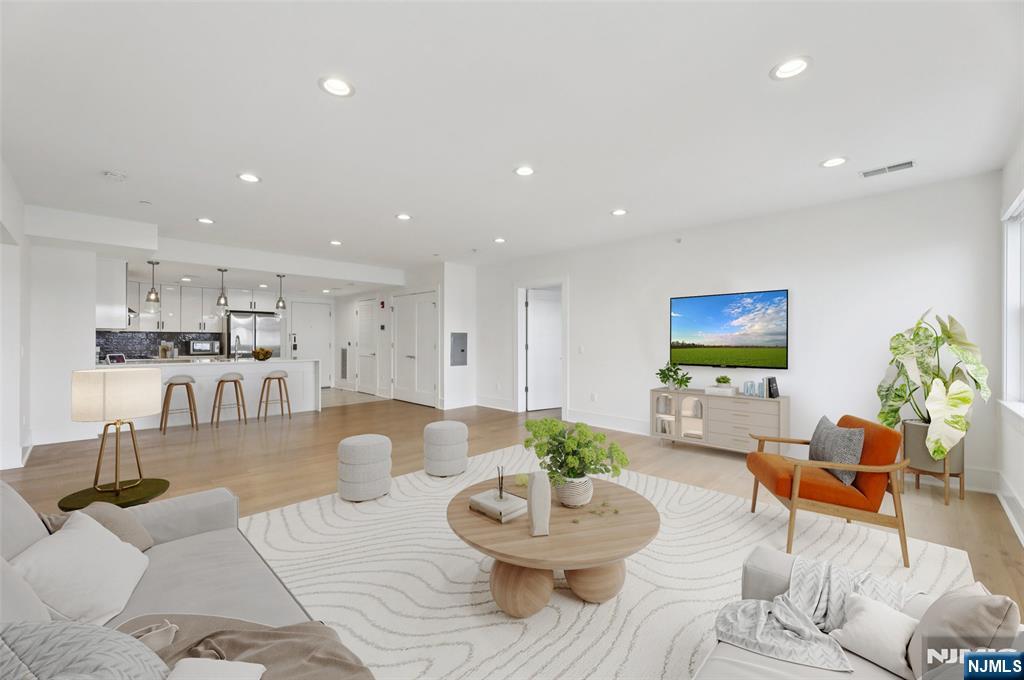 a living room with furniture and a view of kitchen