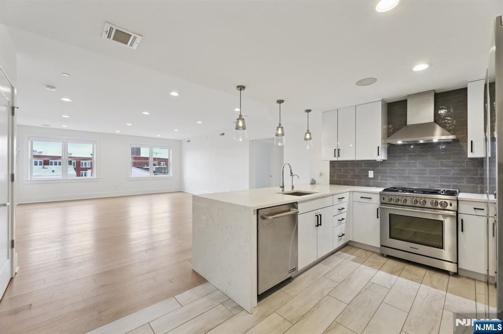 209-211 Hackensack Plank Road, Unit 5B Weehawken, NJ 07086 - Photo 14 of 30 a kitchen with stainless steel appliances granite countertop a stove a sink and a refrigerator