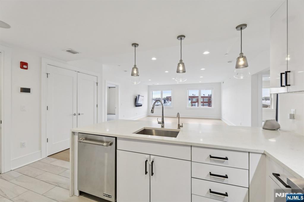 209-211 Hackensack Plank Road, Unit 5B Weehawken, NJ 07086 - Photo 16 of 30 a kitchen with kitchen island white cabinets and white appliances